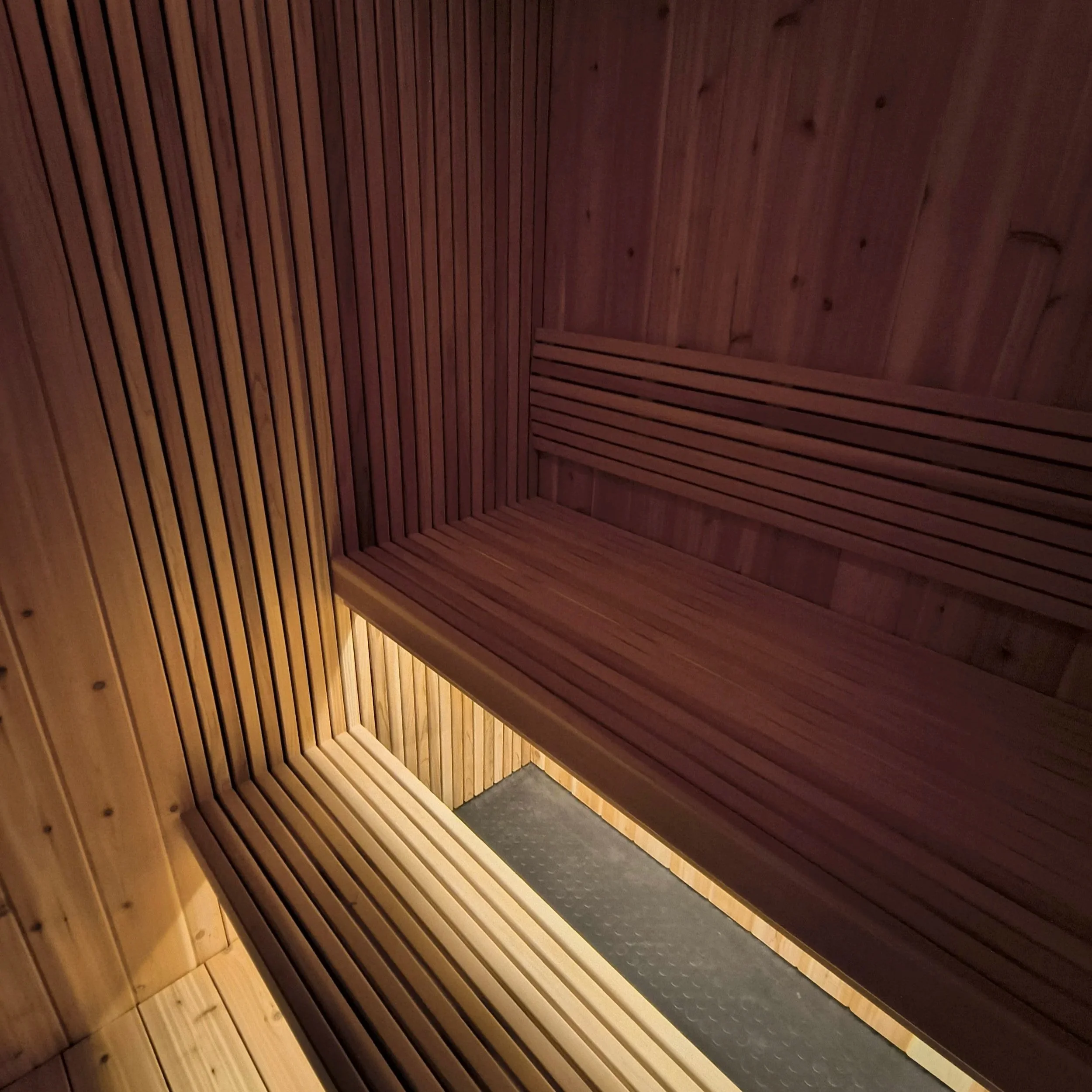 Close-up of custom sauna craftsmanship showing wood paneling and bench construction
