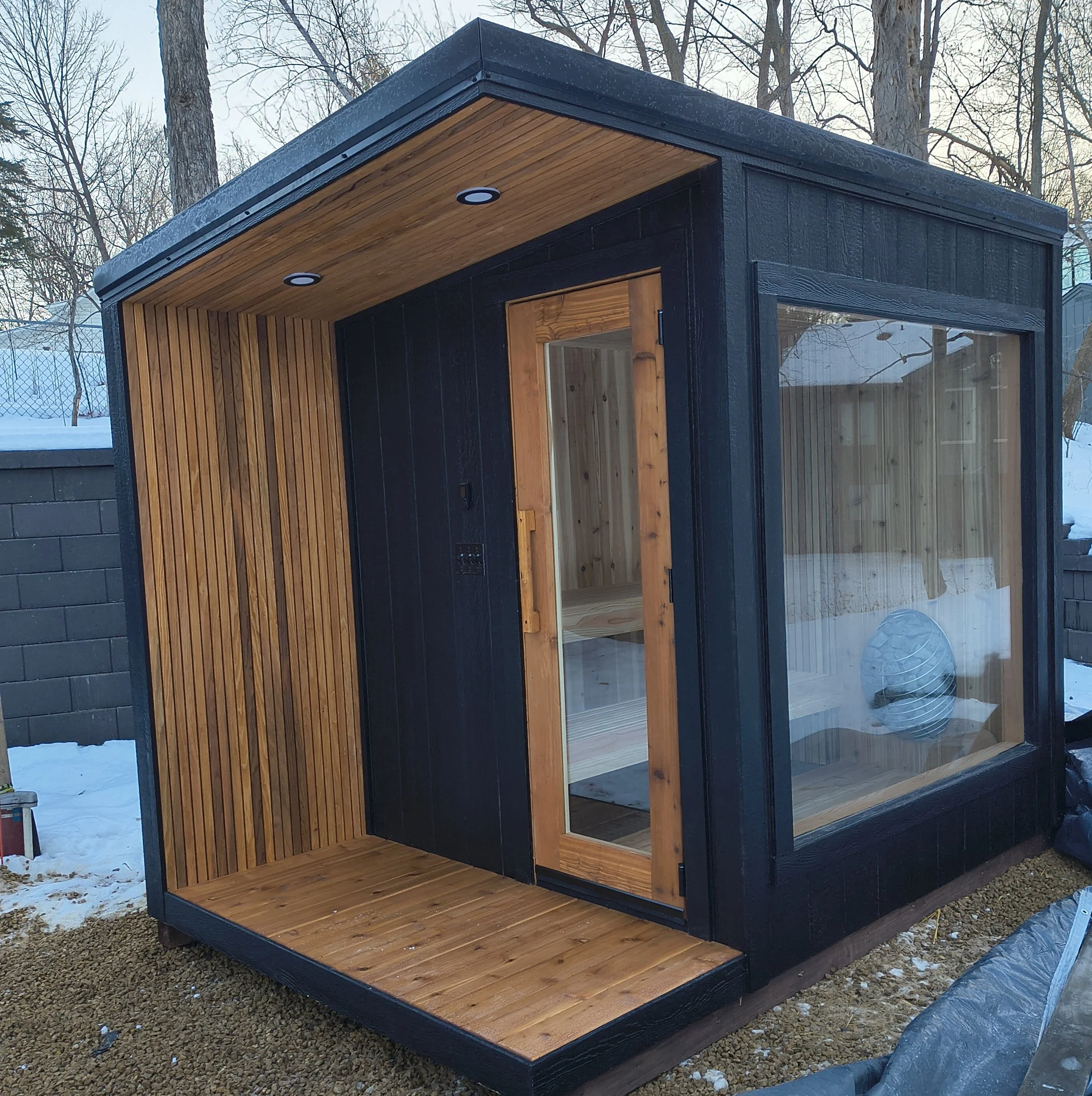 Outdoor custom sauna featuring natural wood construction and professional heater installation