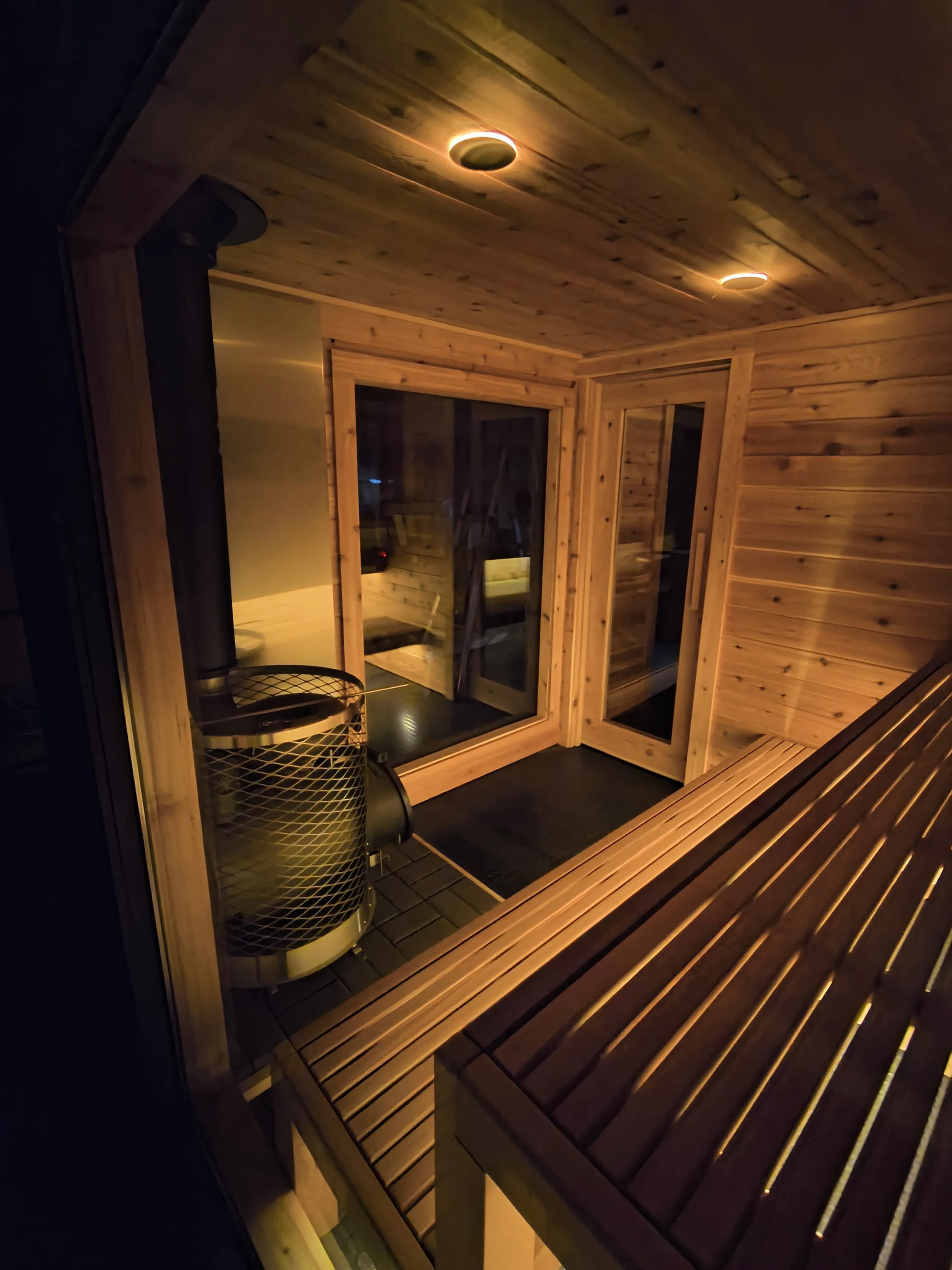 Modern custom sauna with glass front and minimalist wood interior built locally