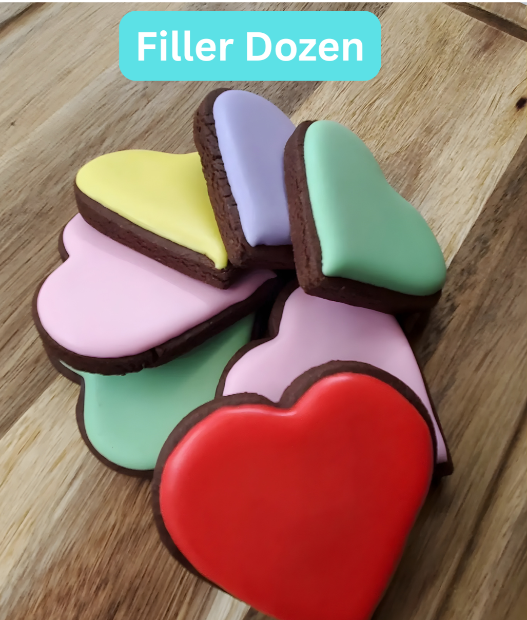 A group of colorful heart-shaped cookies with icing, arranged on a wooden surface, labeled as a 'Filler Dozen'.