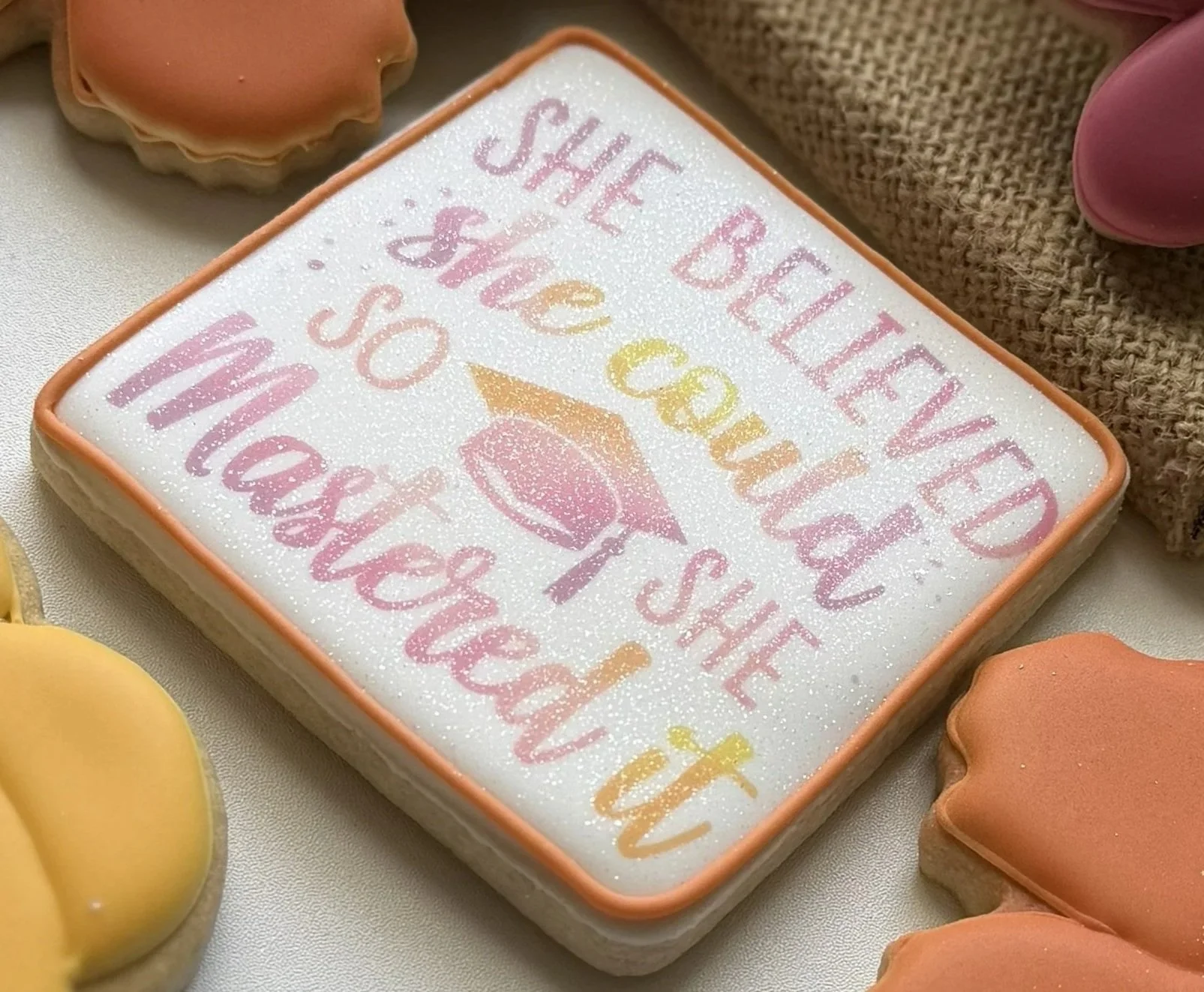 Decorated sugar cookie with the message 'She believed she could so she mastered it'.