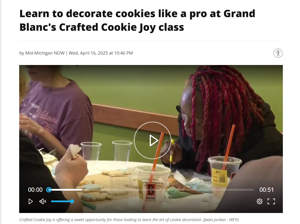 People decorating cookies at a class, with cookies, drinks, and decorating tools on the table.