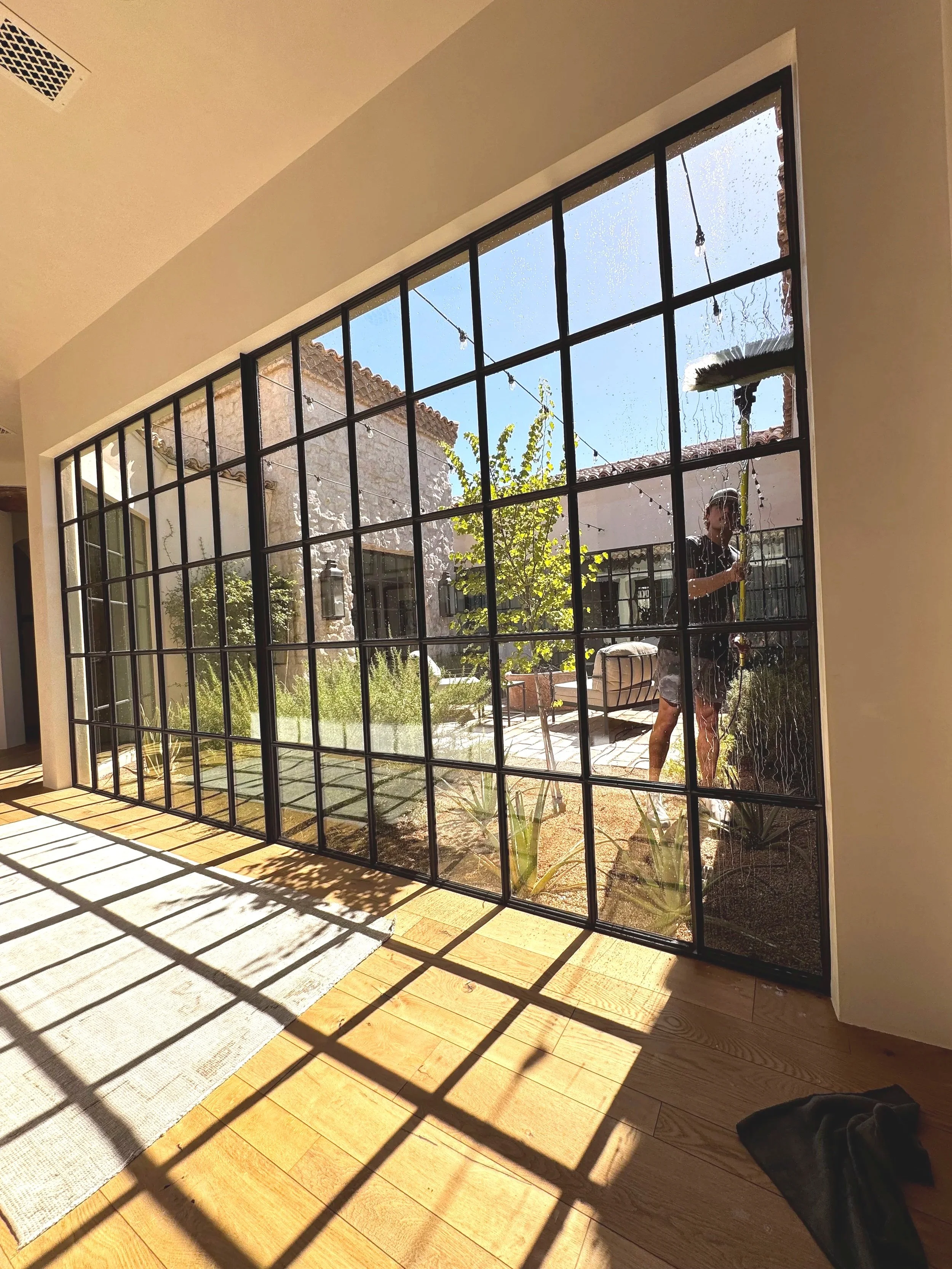 photo of a large window with many panes being cleaned on the outside with a water fed pole pure water system