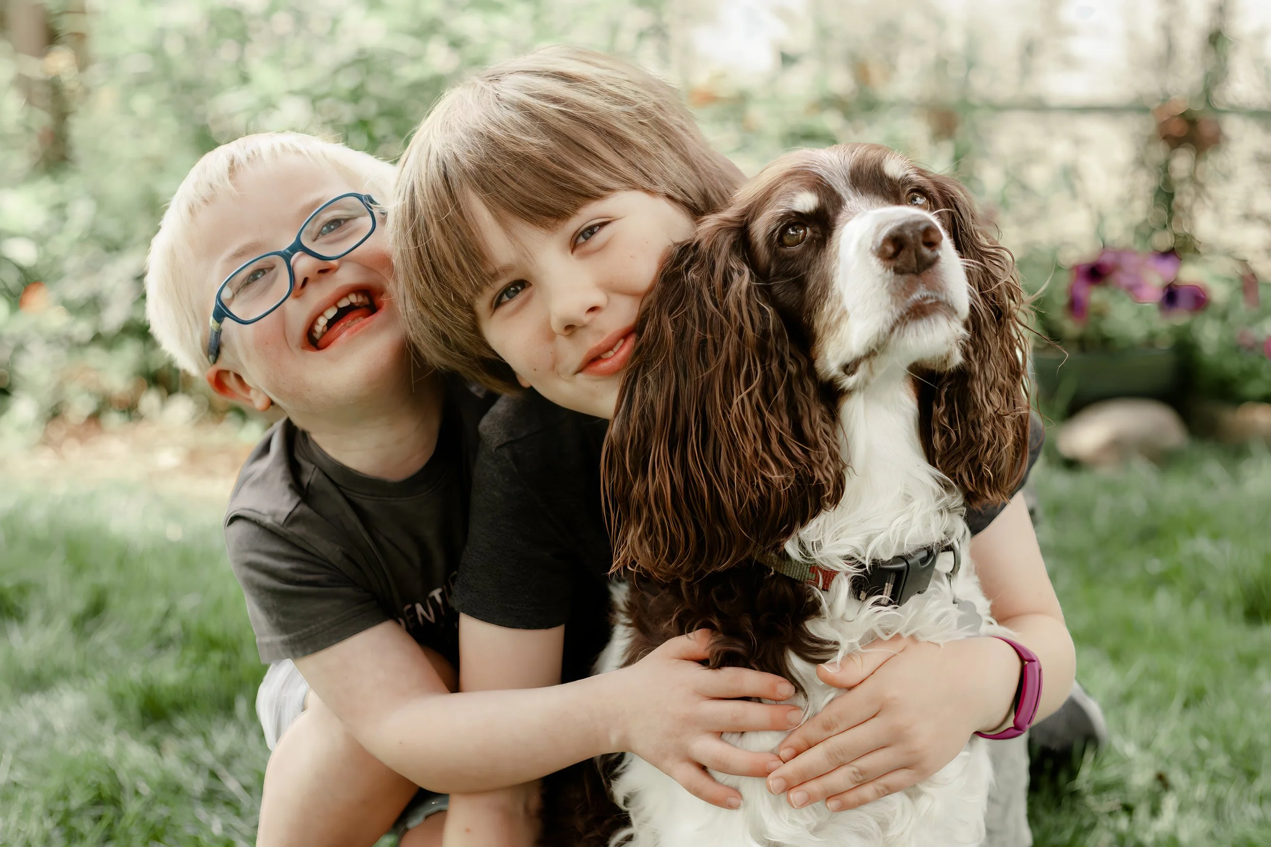 Brothers cuddling dog together during a lifestyle photography session in Minneapolis
