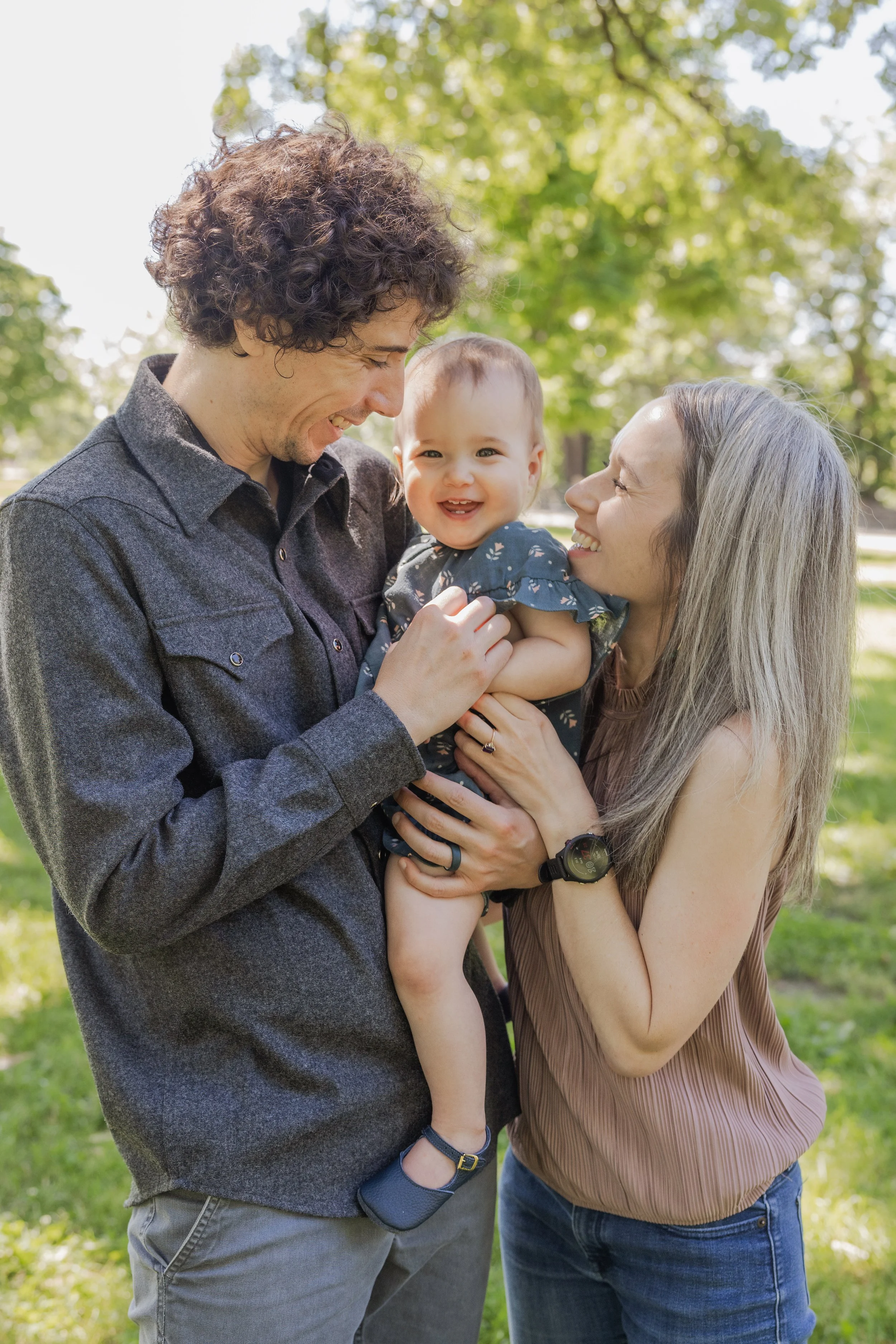 Family of 3 laughing together during a lifestyle photography session in Minneapolis