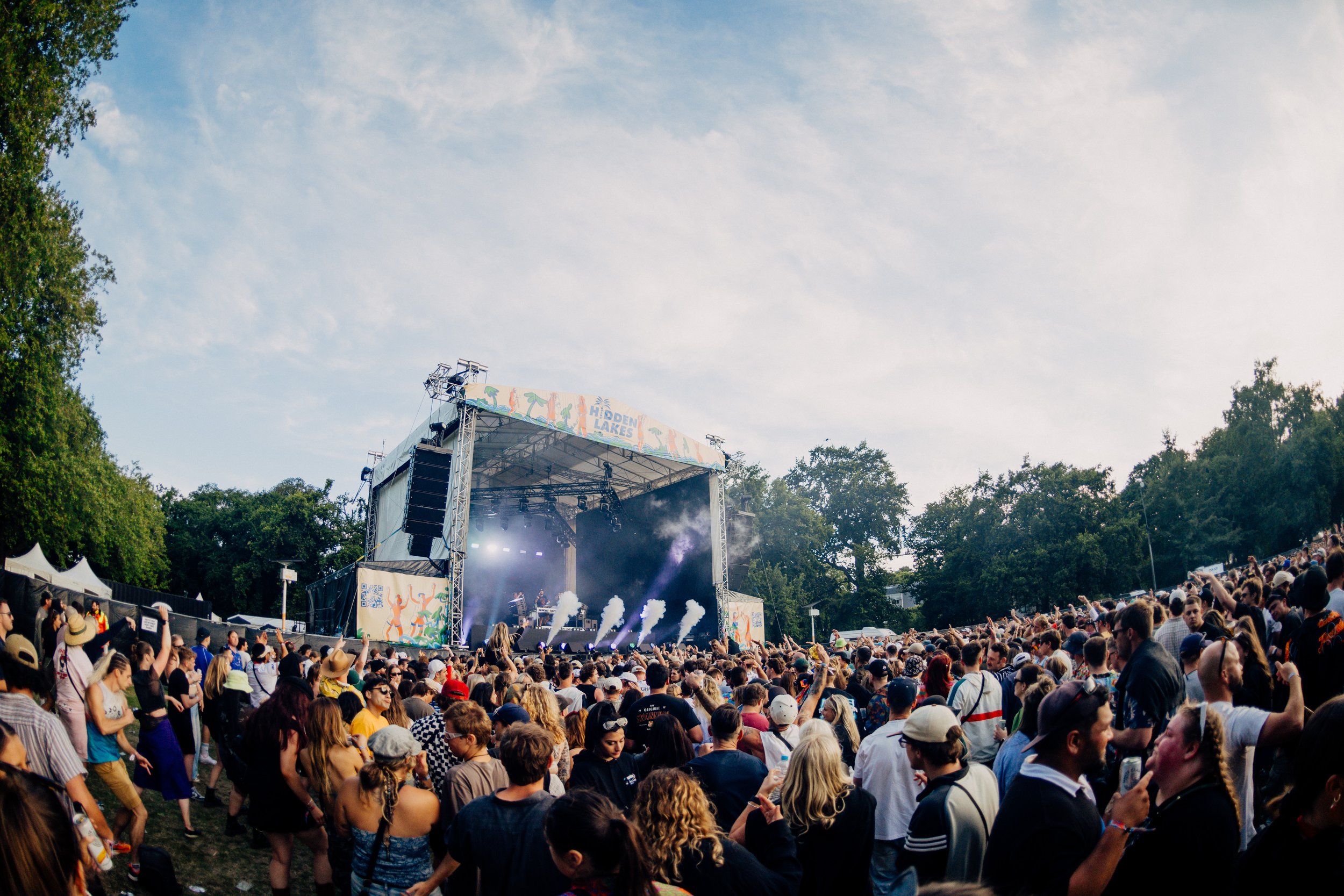 Outdoor music festival with large crowd and stage