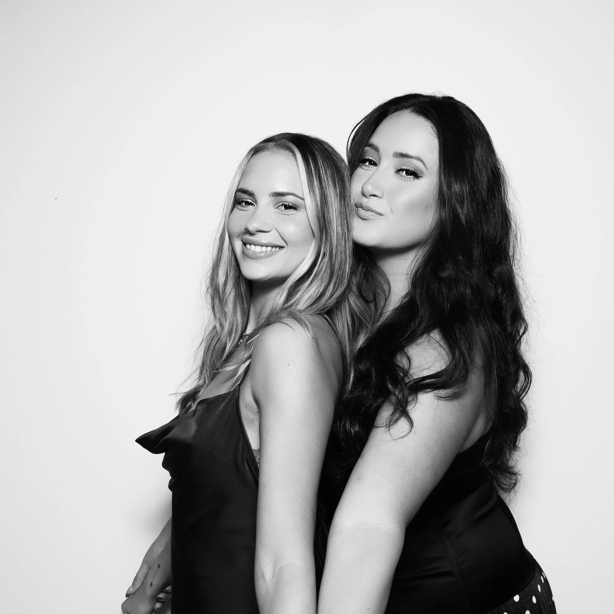 Wedding guests enjoying a Temecula photo booth experience with a luxury green backdrop