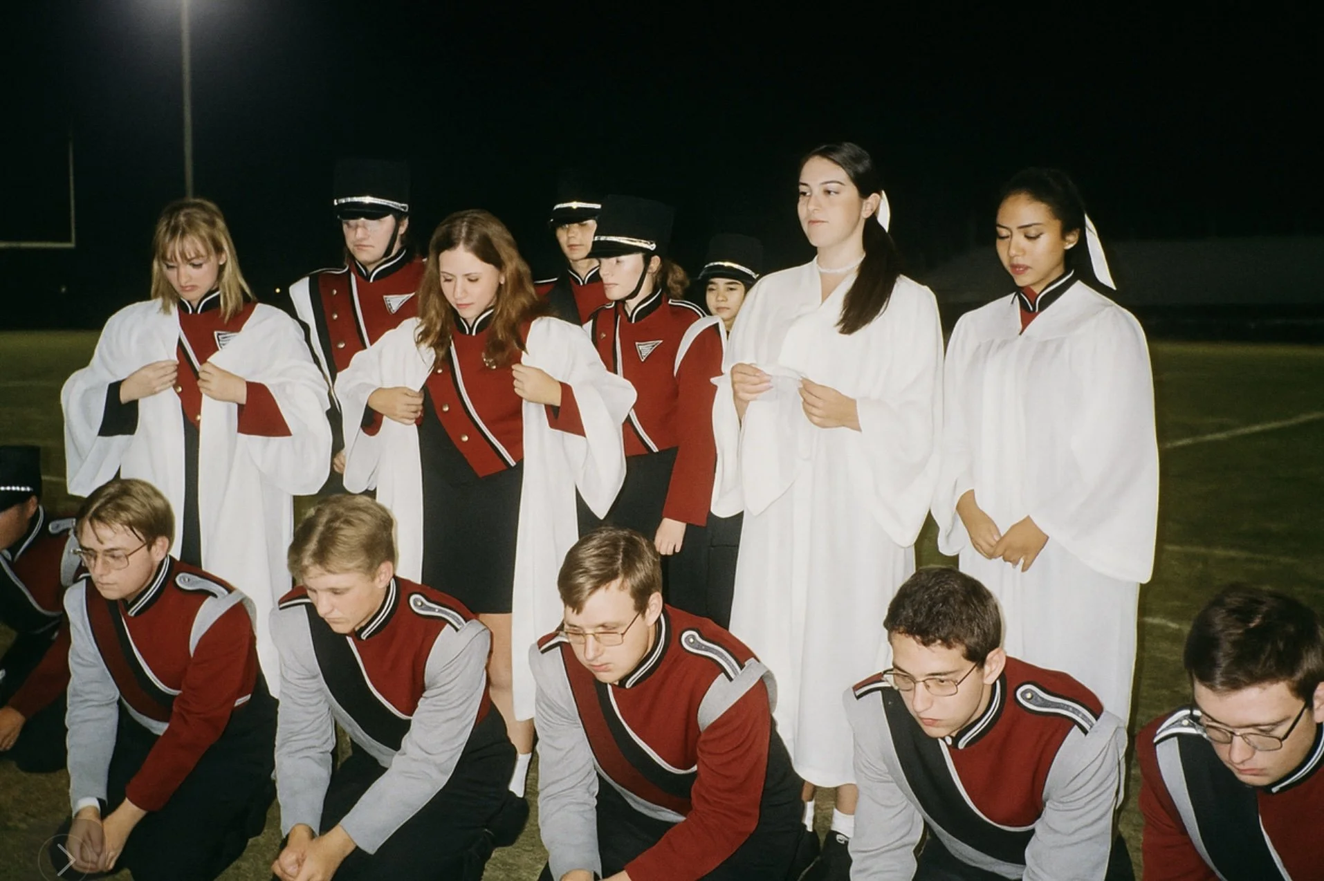  New inductees perform a religious ritual midway through a high school football game. Notice the awkward tension. 