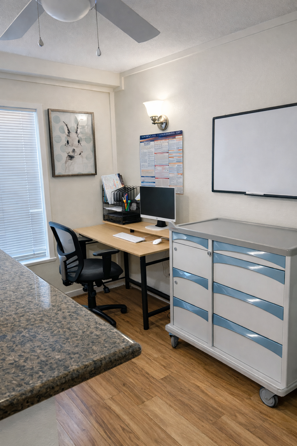 Office workspace with a desk, computer, office chair, whiteboard on wall, filing cabinet, papers, and a window with blinds.