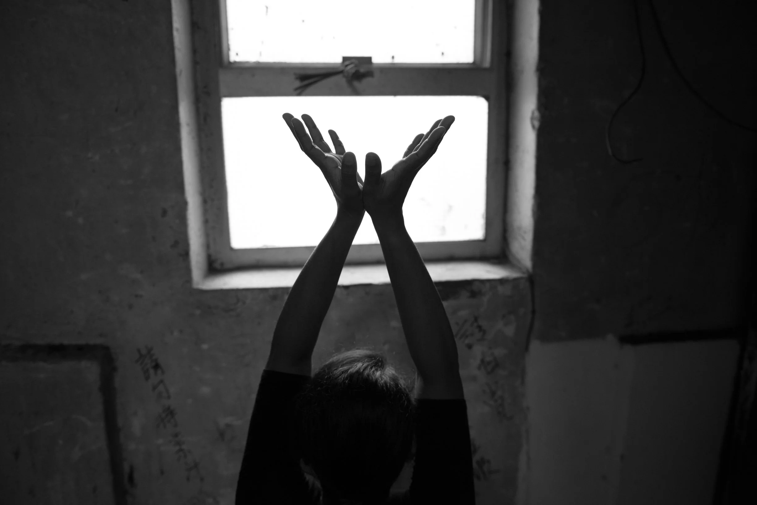 ASK client's child with hands forming a dove shape against window at the home stairwell