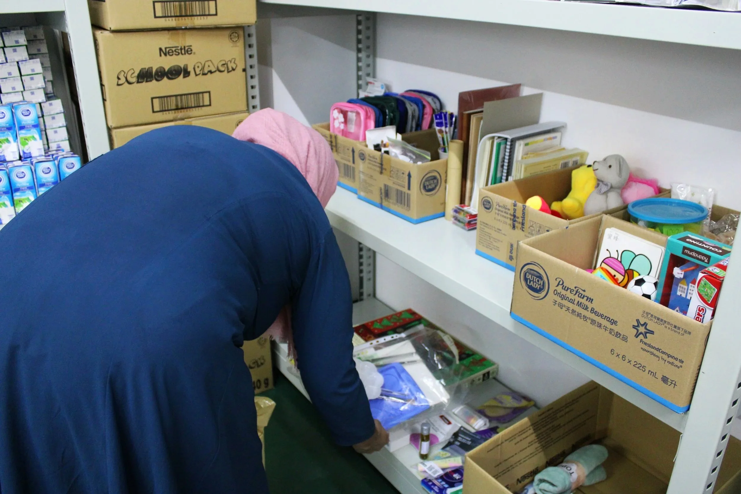 Women looking at children toys and books on warehouse shelve