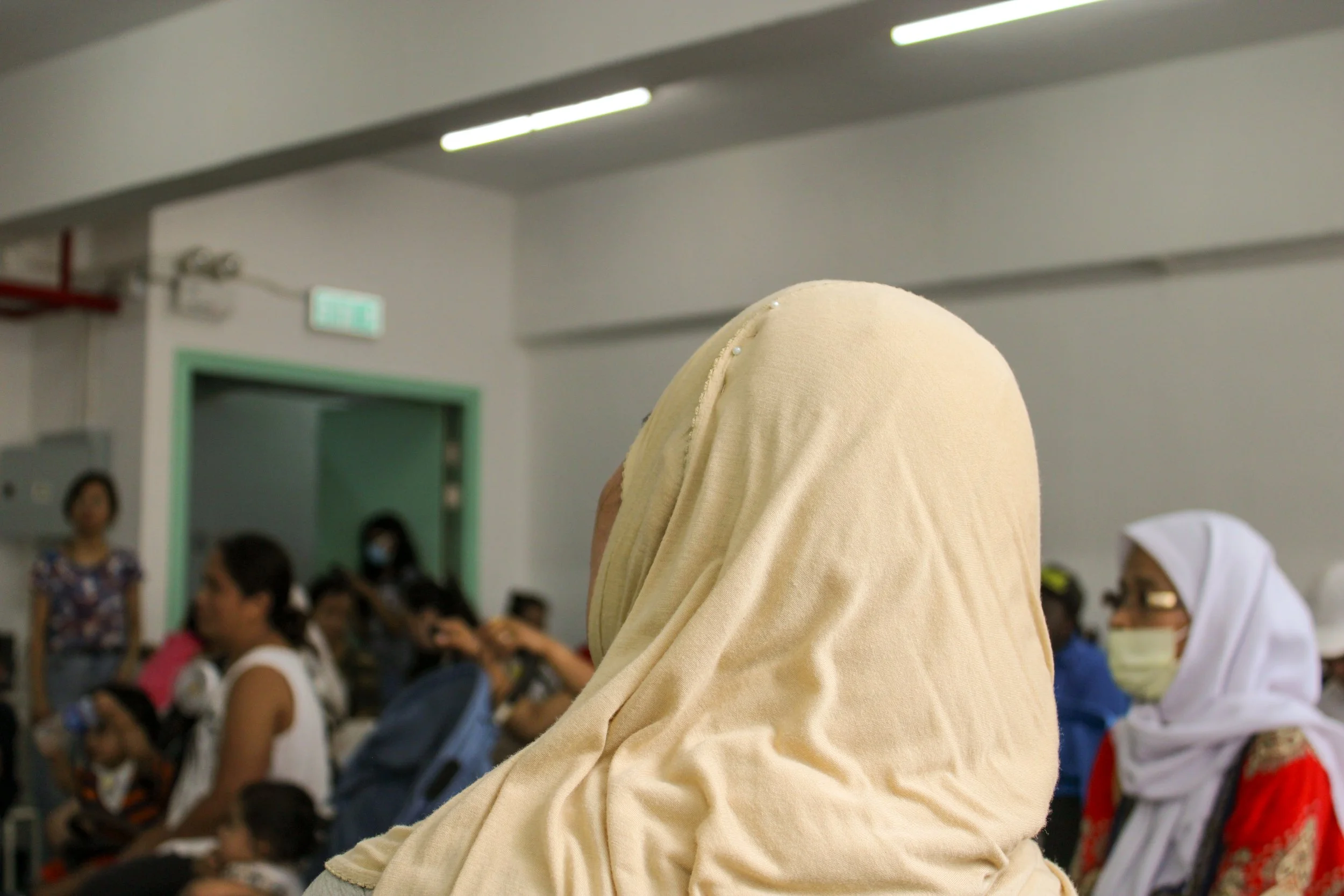 Women with head covering from the back  looking towards a speaker off camera