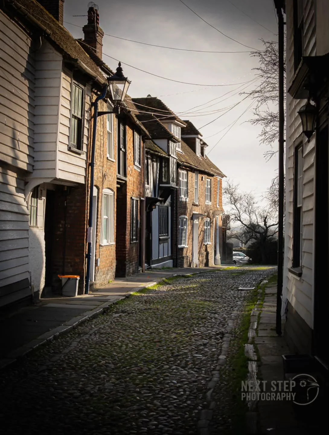 Here's a shot from a recent visit to Rye!

I love capturing that atmospheric feeling with my shots - I like to imagine how'd the locations would appear in a film or a game.

Here, I imagine a detective ambling down the street in twilight, trying to p