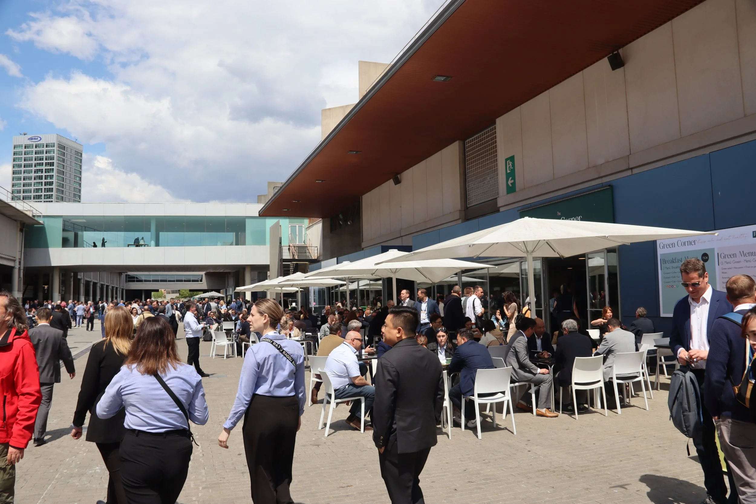 A crowd of people outside walking around in formal clothing