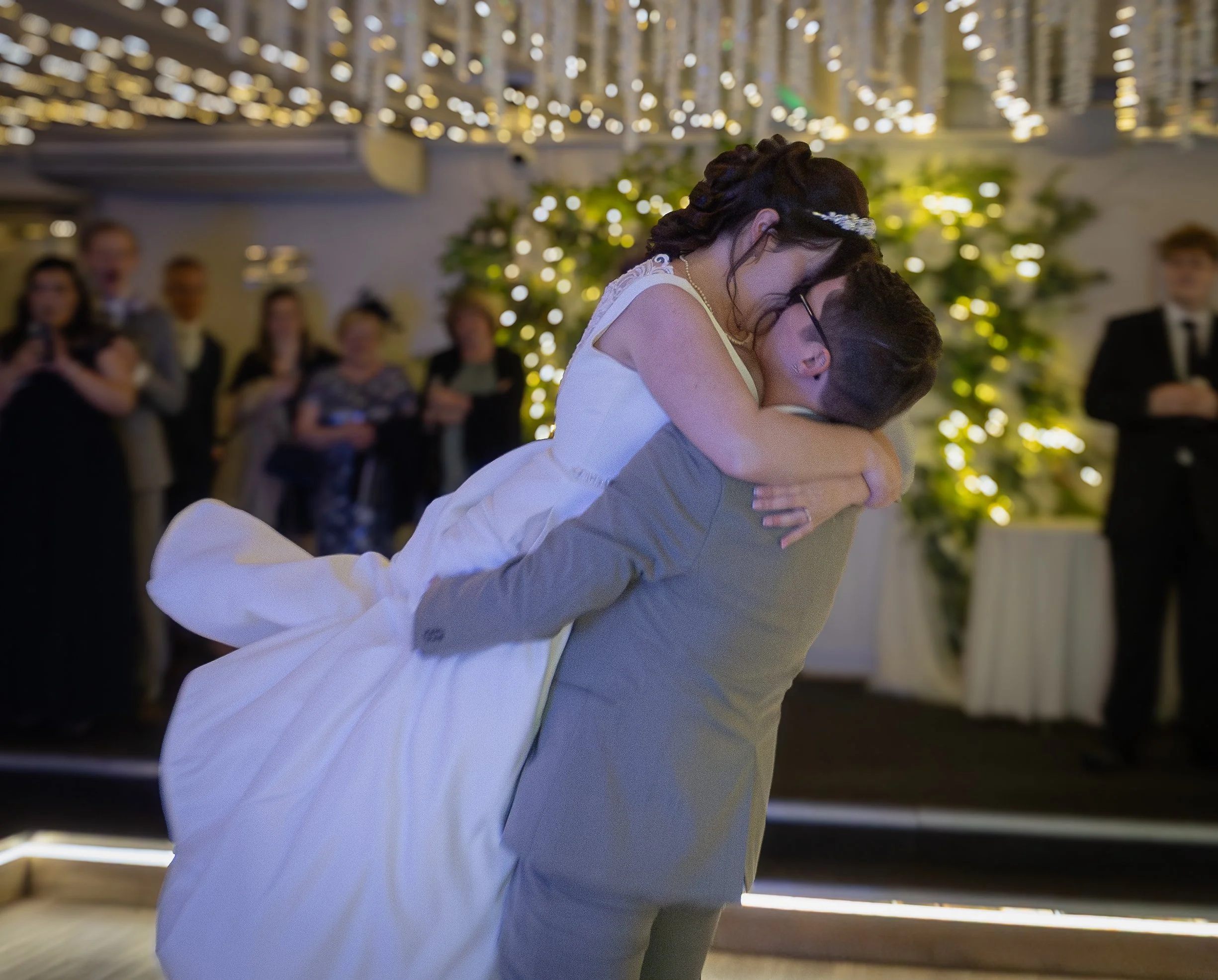 A man lifting his wife during their first dance at their wedding