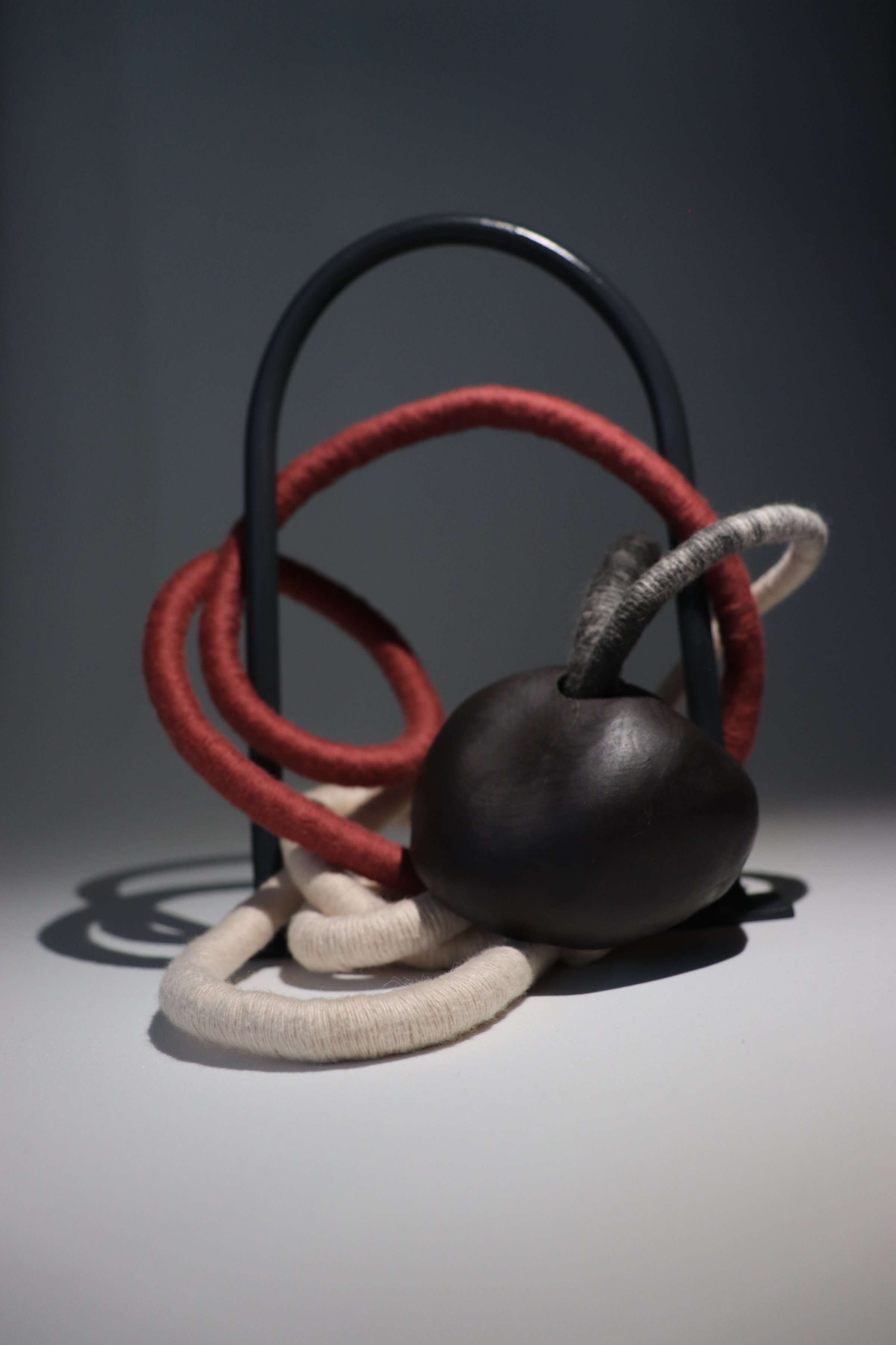 Abide, 2025. Steel, cotton thread, rope, black midfire clay form.