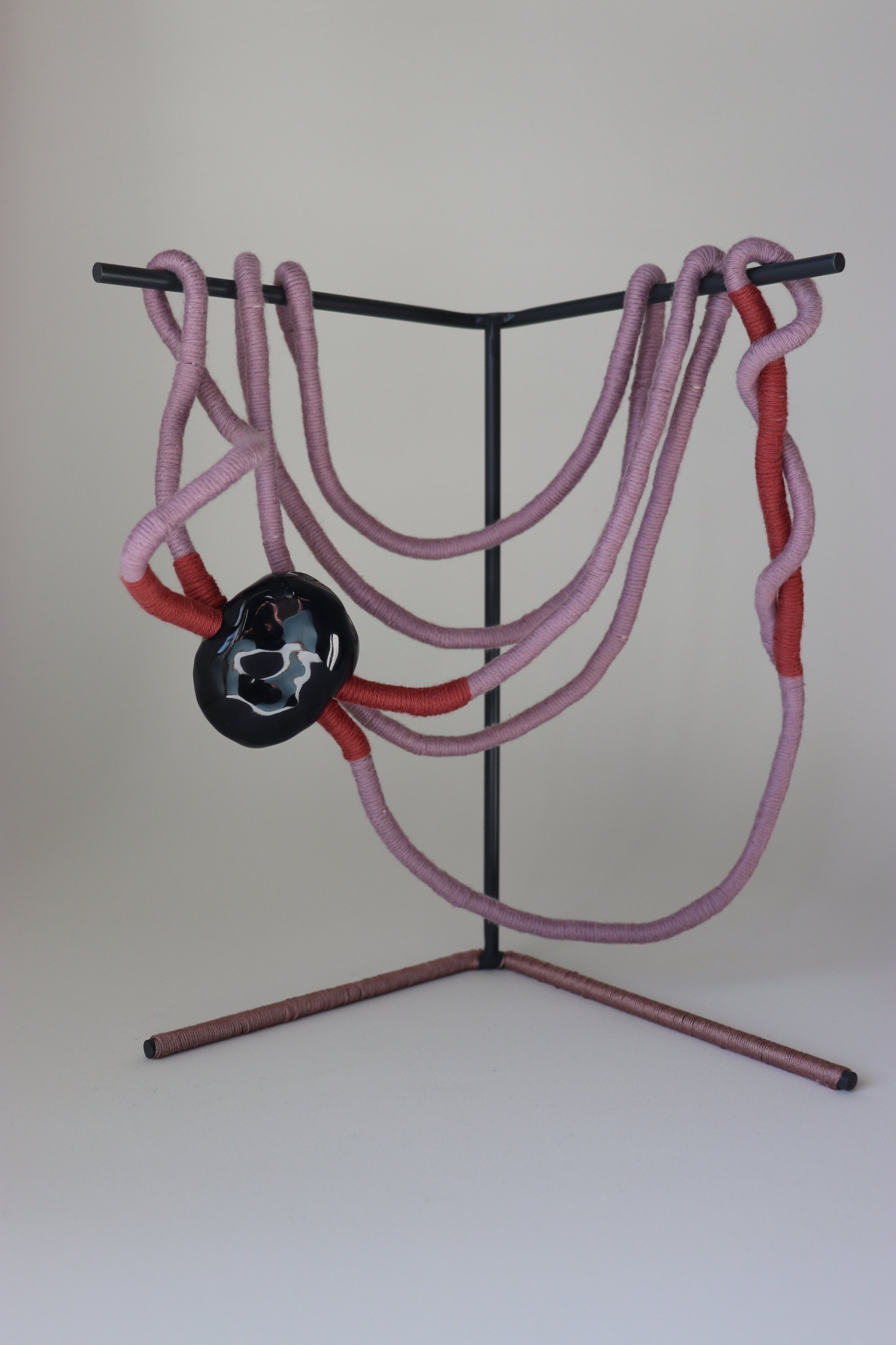 Bared, 2025. Steel, paint, glazed ceramic forms, rope, cotton thread.