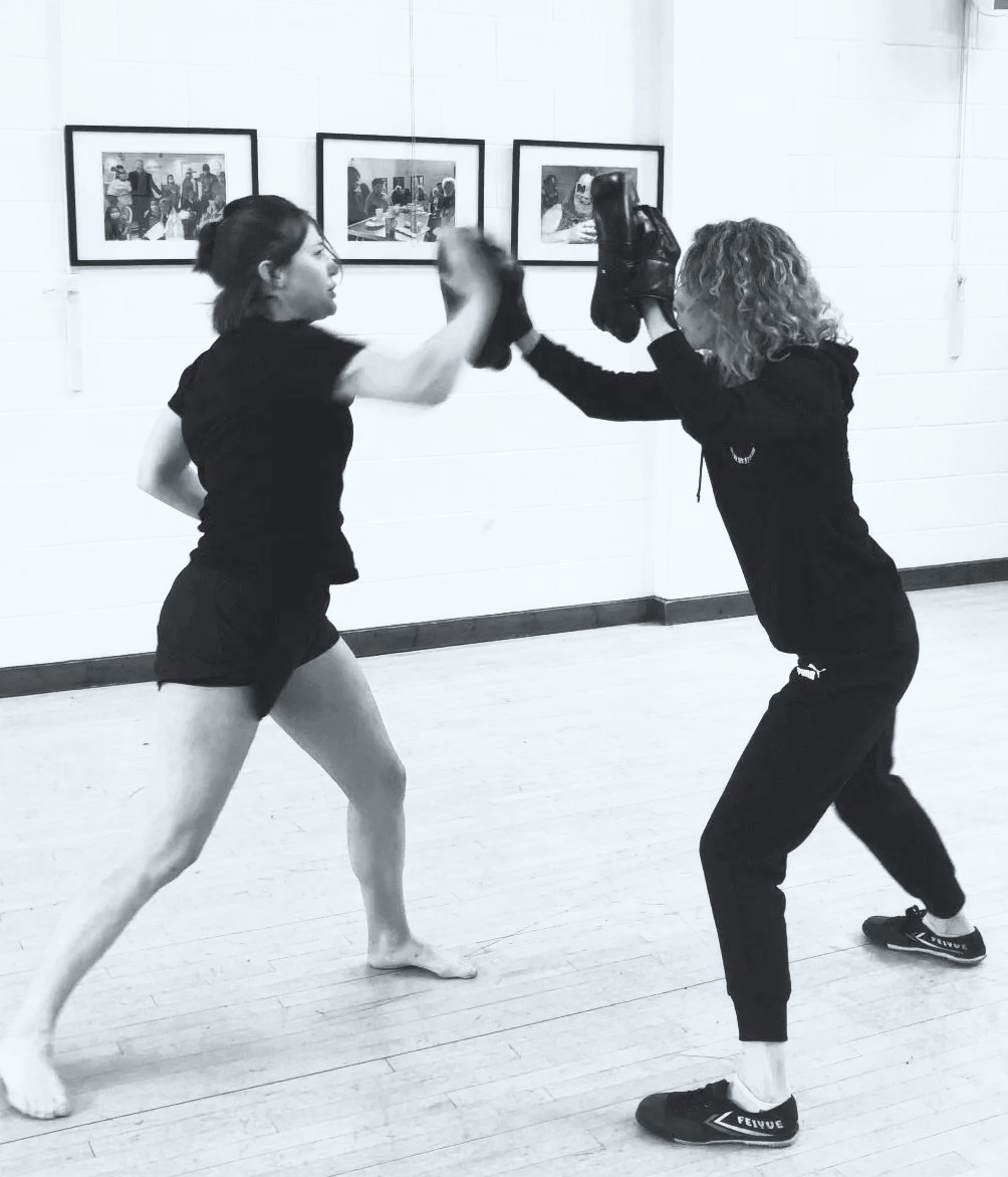 Woman practising palm strikes for self-defence with a coach