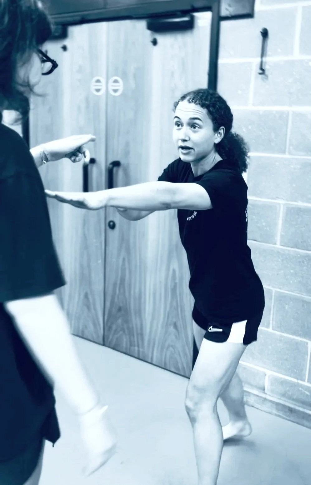 A woman demonstrating the fence position for managing personal space in self defence