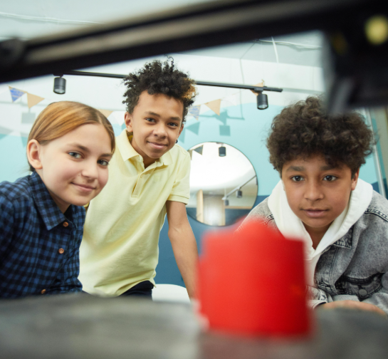 Three children looking at a 3d printed object in a lab setting