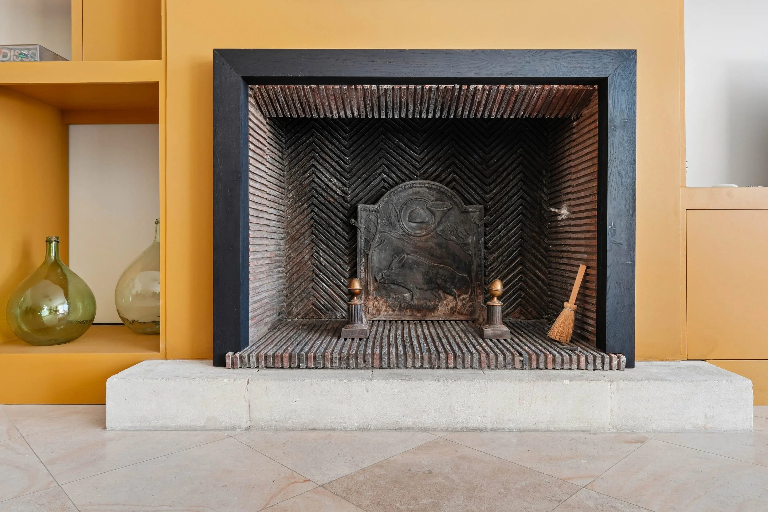 Cheminée ancienne réhabilitée avec encadrement contemporain noir, intégrée dans un meuble sur mesure à Colombes.