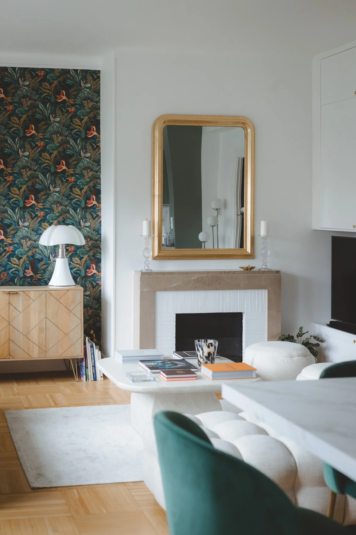 Salon lumineux avec menuiserie semi sur mesure, et papier peint panoramique végétal. Un espace chaleureux et personnalisé dans cet appartement rénové à Caen.