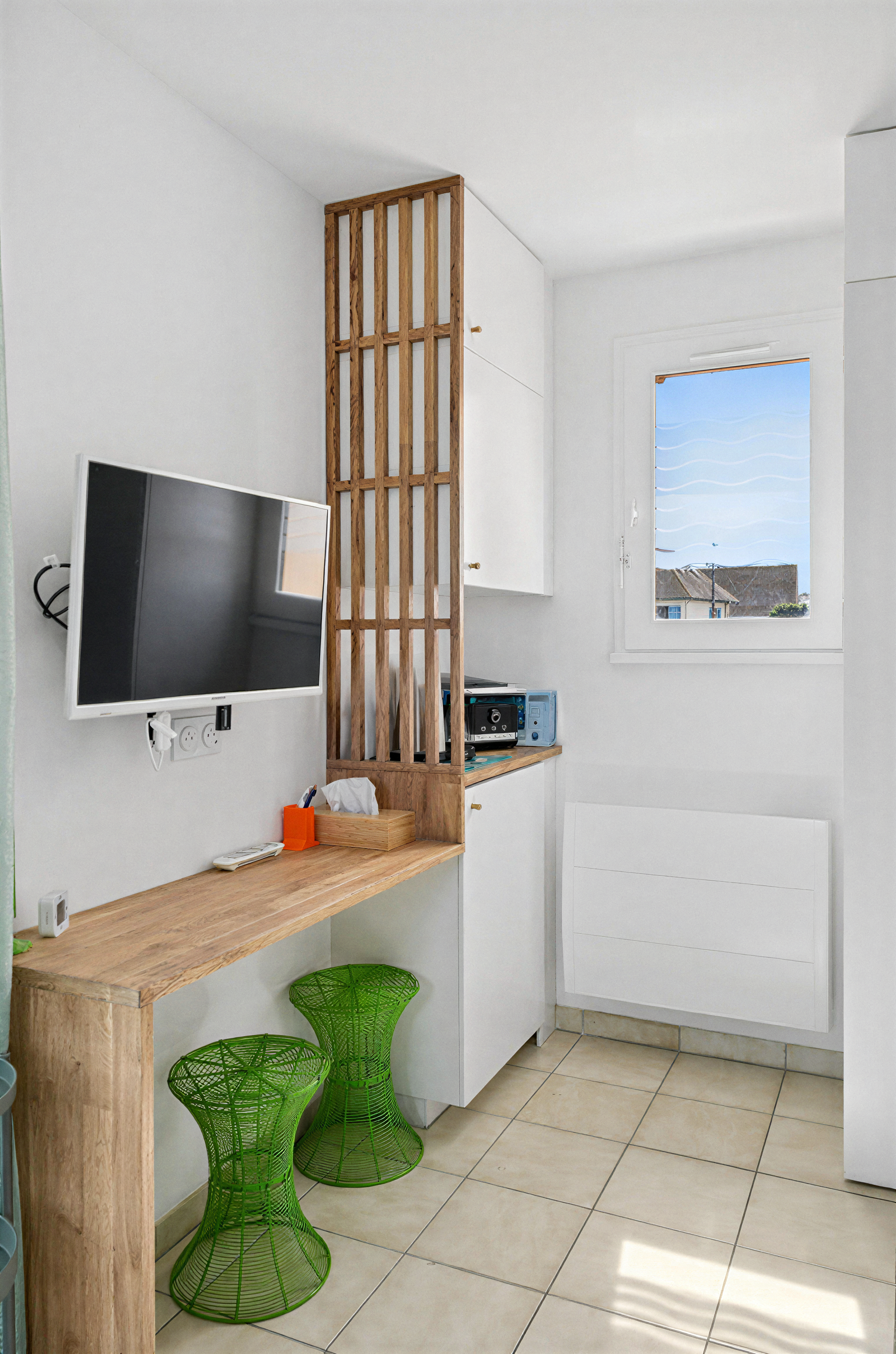 Coin bureau avec rangements et claustra en bois aménagé dans un appartement de 30 m² à Ouistreham.
