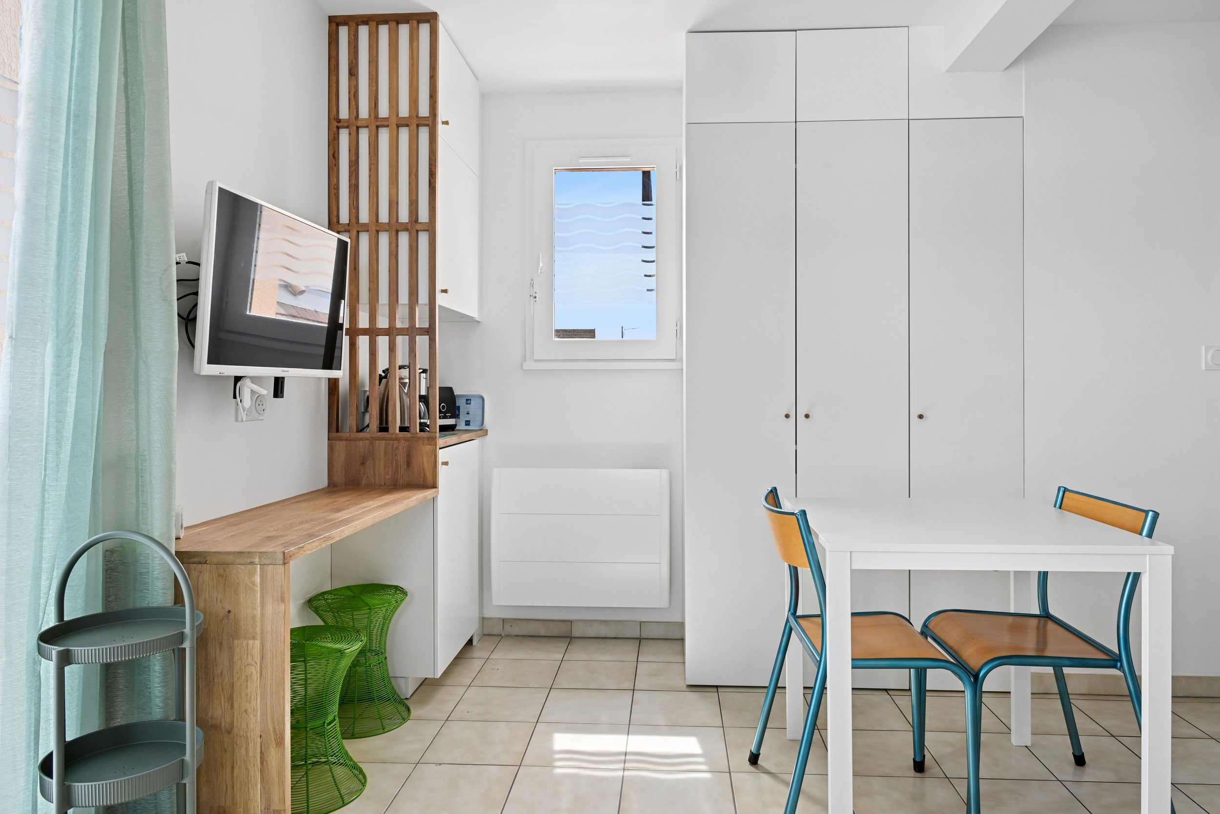 Coin bureau avec rangements et claustra en bois aménagé dans un appartement de 30 m² à Ouistreham.