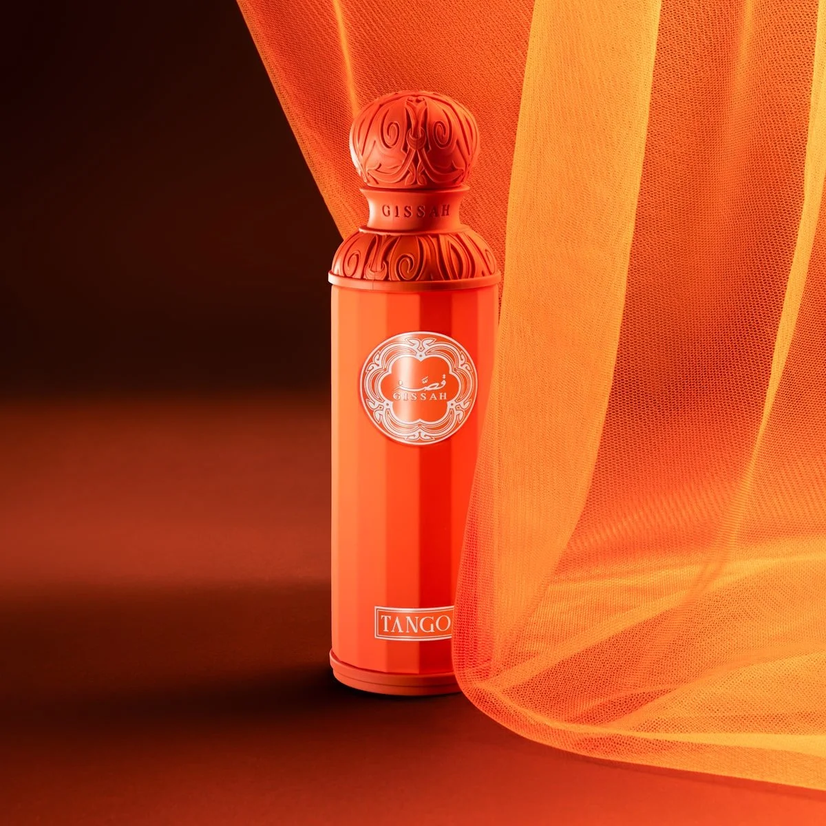 Gissah TANGO Eau De Parfum in dark orange setting with flowing curtain – sweet summer perfume for men and women – Al Rashid Galleria UK