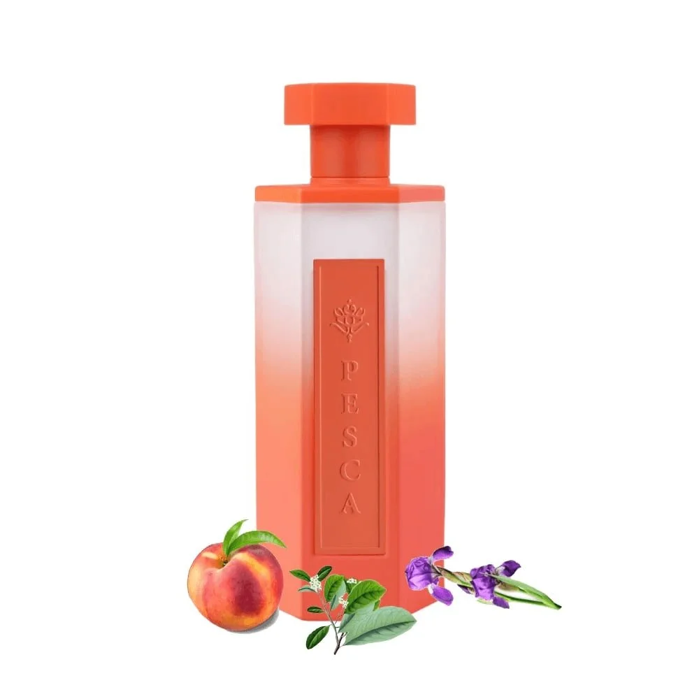 Pesca fragrance bottle surrounded by fresh peach slices, iris petals, and maté leaves on white background