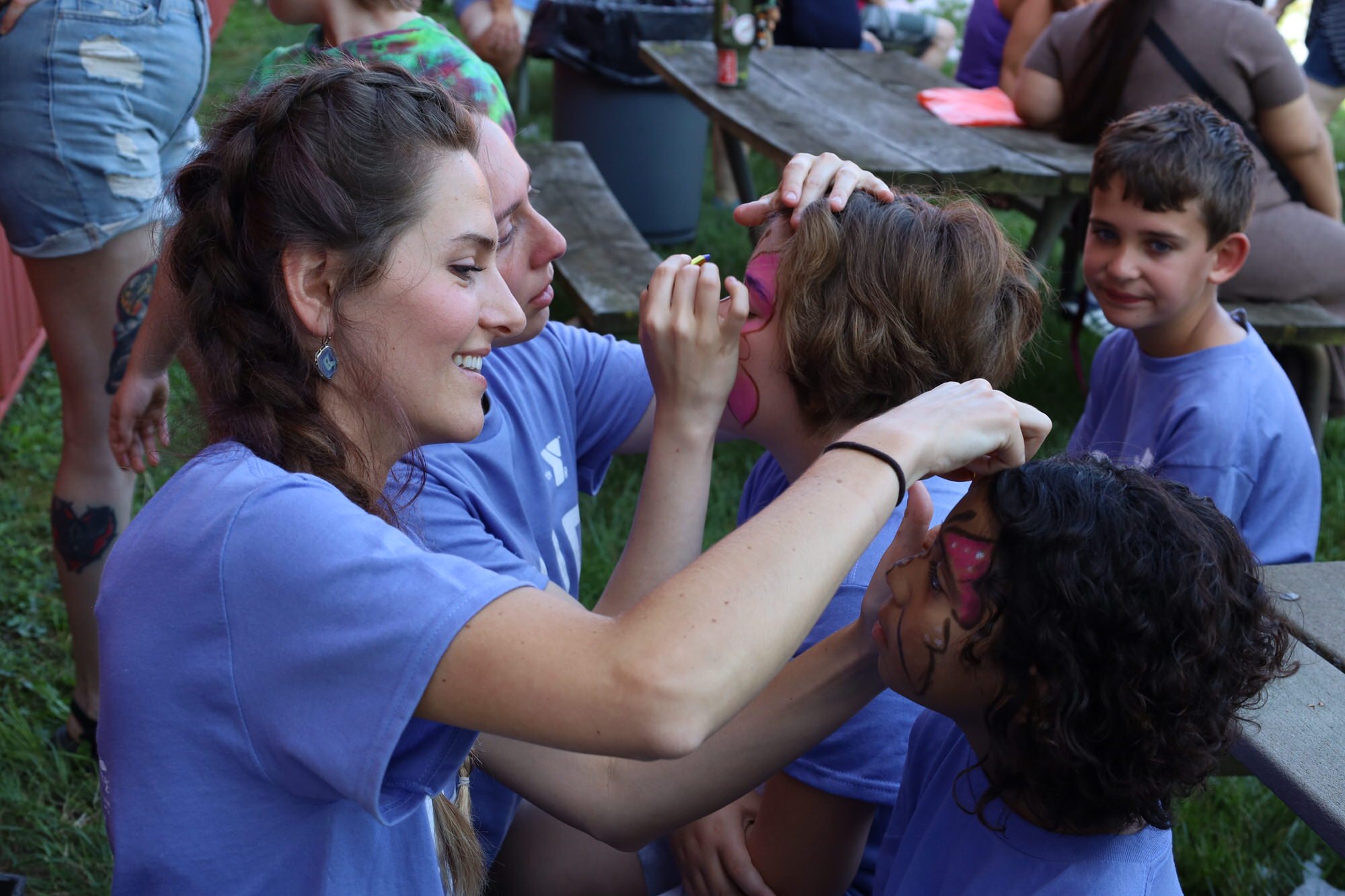 A young woman applied face paint to a child