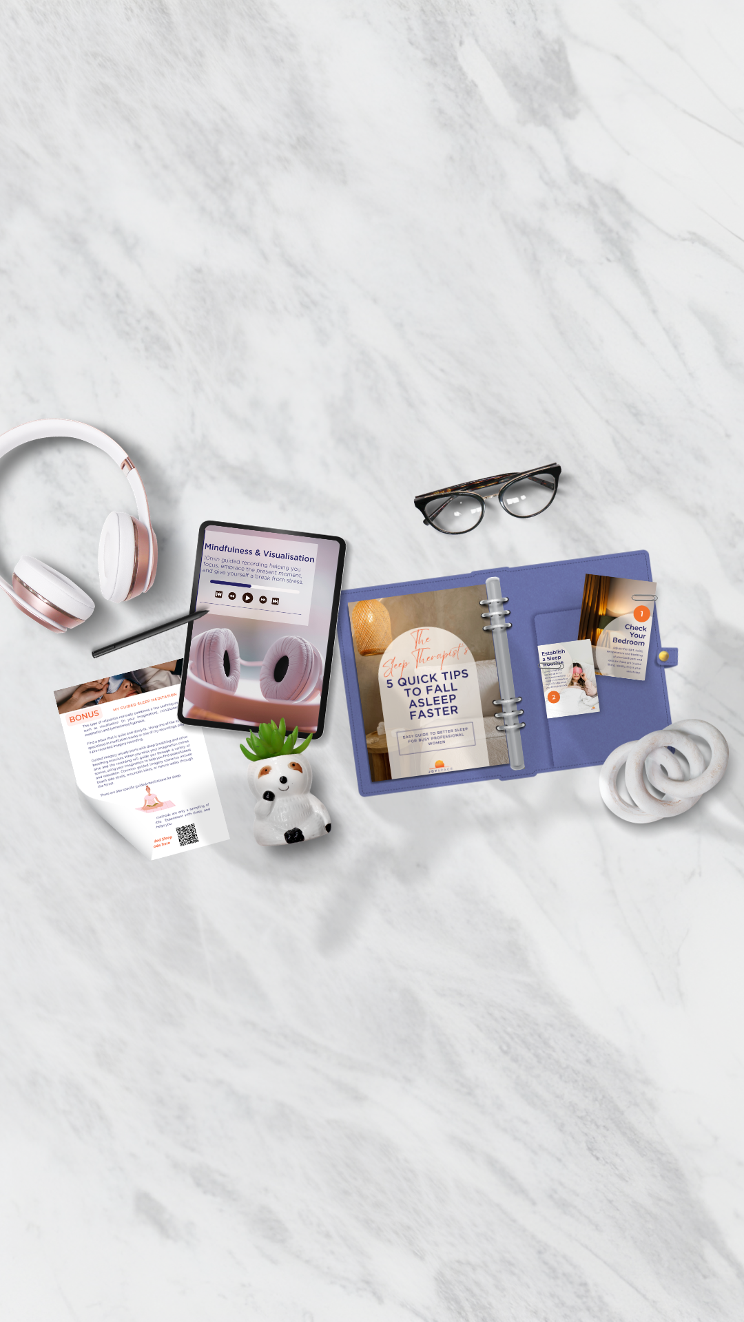 A flat lay of sleep relaxation items on a white marble surface, JoySpace Therapy bundle.