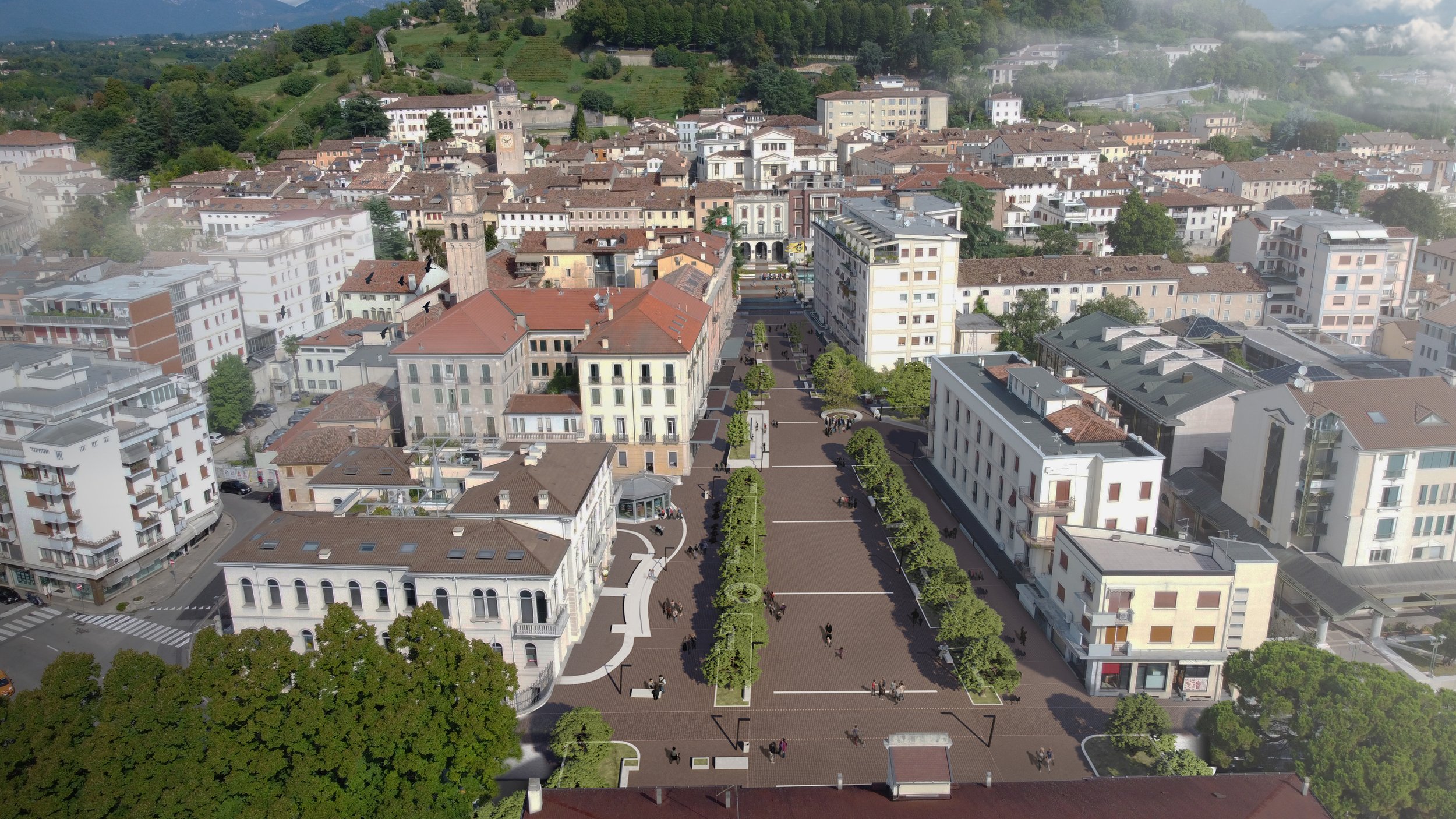 Vista aerea di una piazza nel centro di una città italiana, con alberi piantati lungo il viale e edifici storici sullo sfondo.
