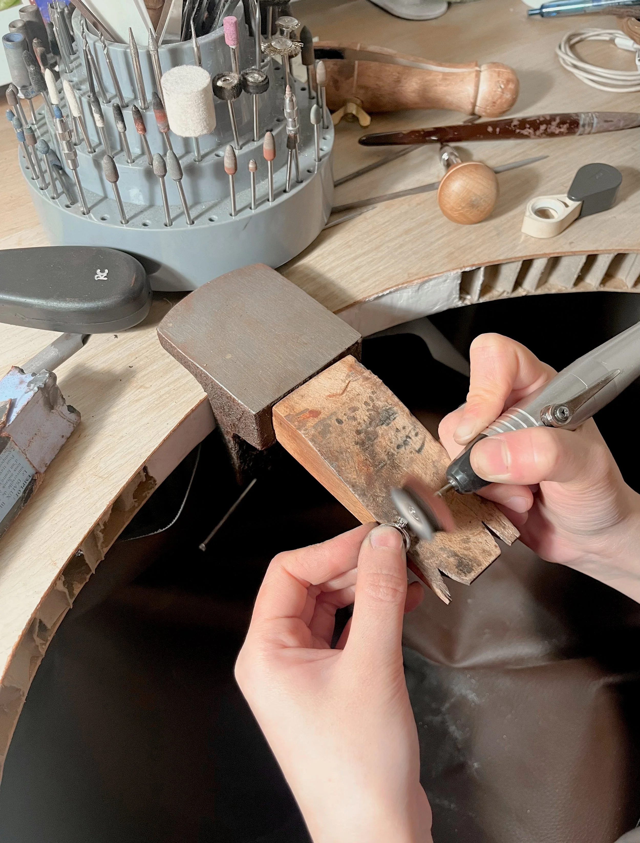 Close-up of hands holding a polishing tool for the jewellery making process