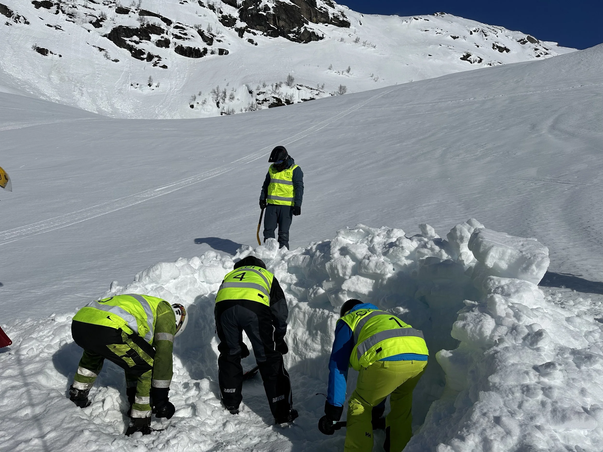Fire personer på snøskuterkurs i Røldal, alle iført reflekterende vester og vinterklær.