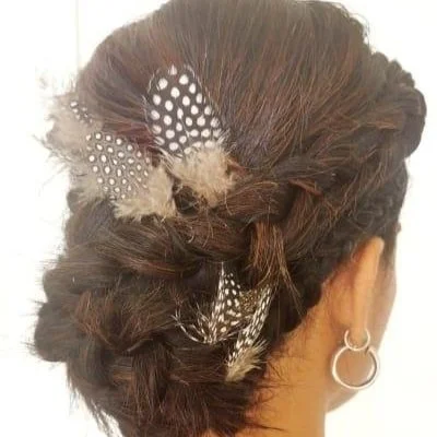 Woman with braided hairstyle adorned with feathers