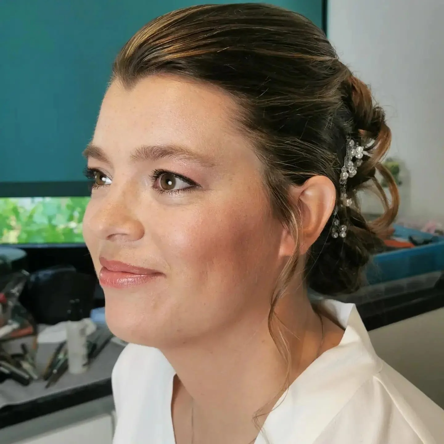 Woman with updo hairstyle, hair adorned with decorative clips.