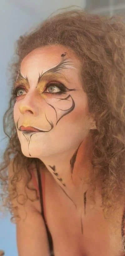 Person with artistic face makeup and curly hair
