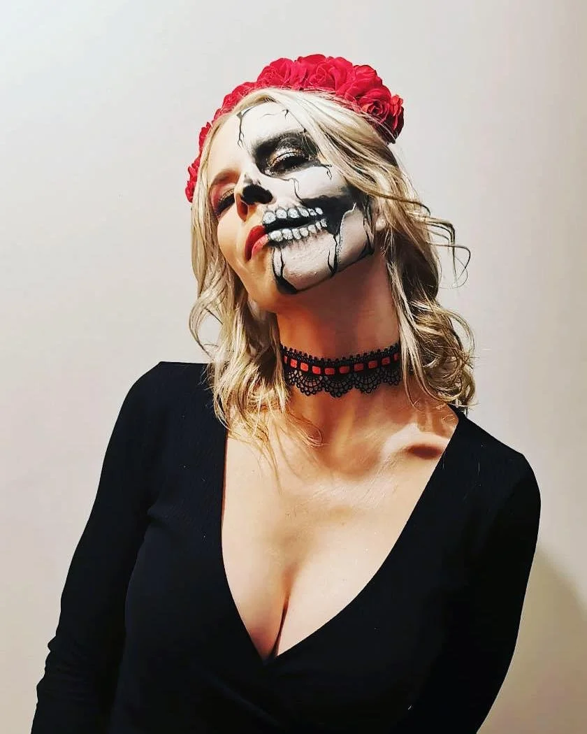 Woman with sugar skull makeup and red floral headband