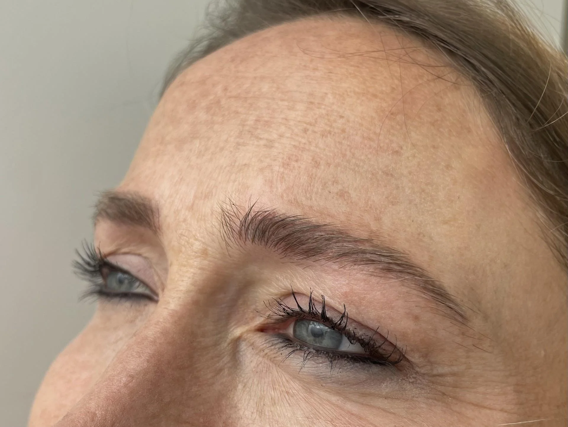 Close-up of a person's eyes and forehead, showing eyebrow details and skin texture.