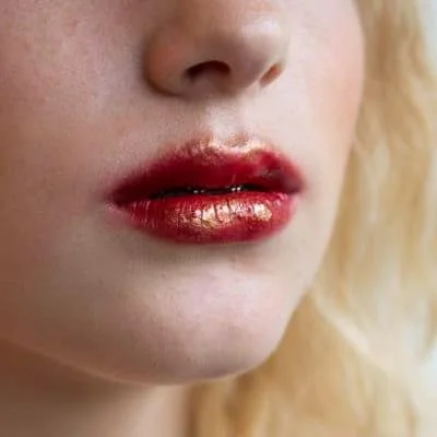 Close-up of lips with metallic red and gold lipstick