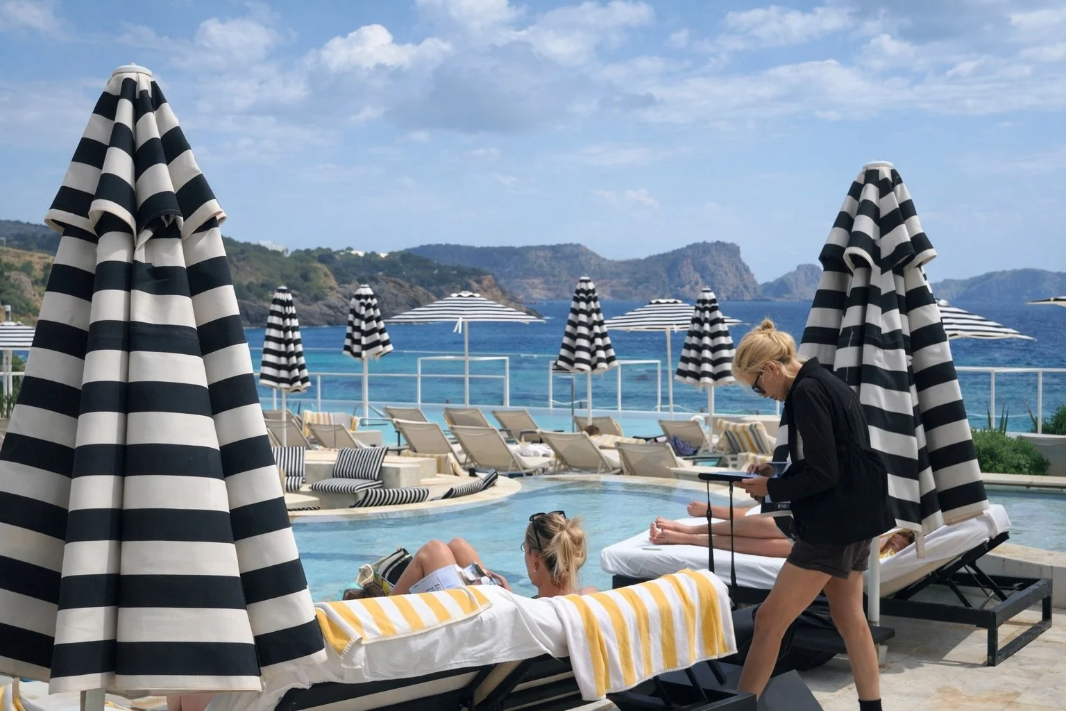 Massage Beach Ibiza therapist engaging with guests poolside at a luxury hotel venue