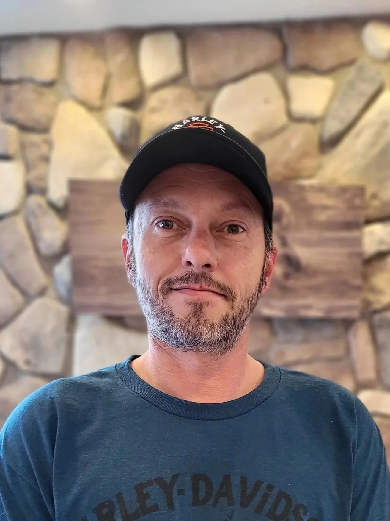 Maintenance Manager Aaron Price wearing a black cap and blue hoodie