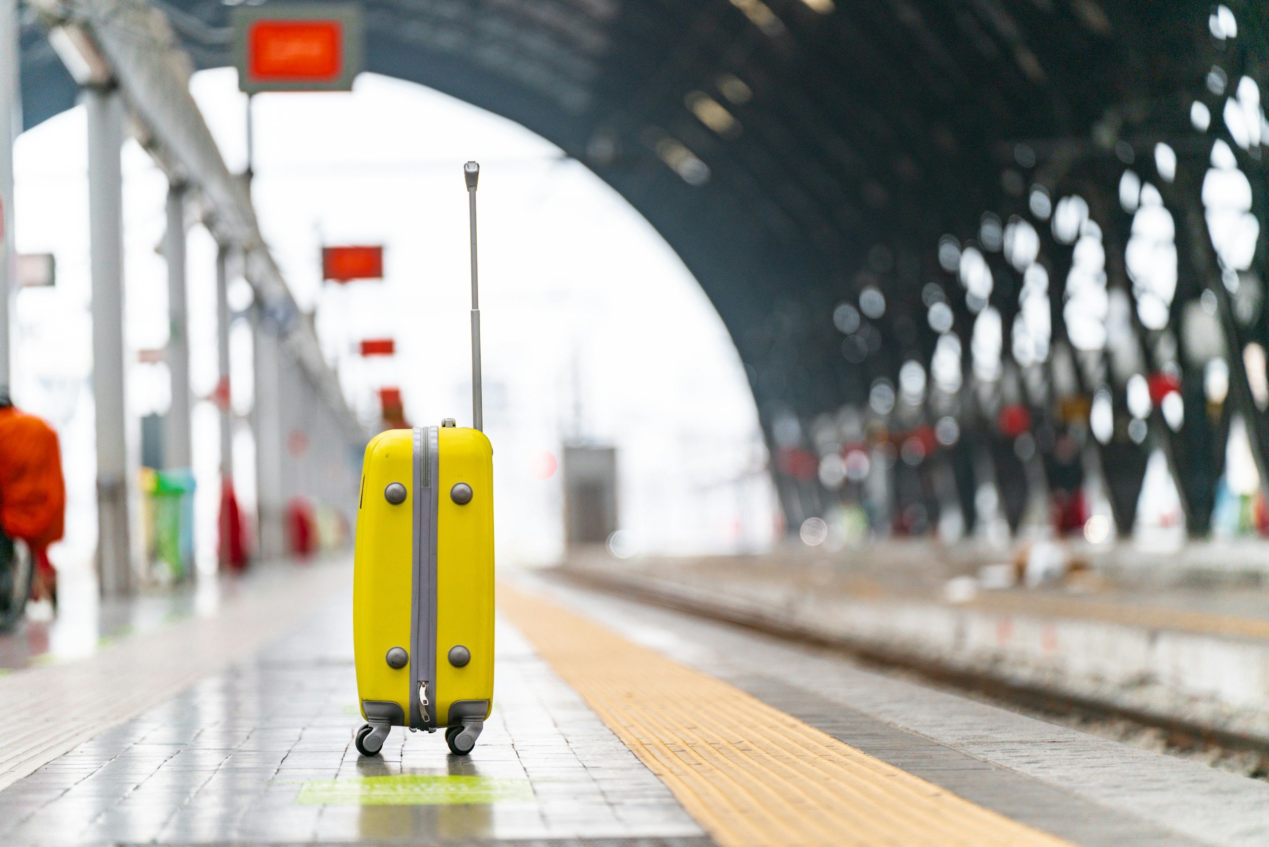 yellow suitcase on a train track