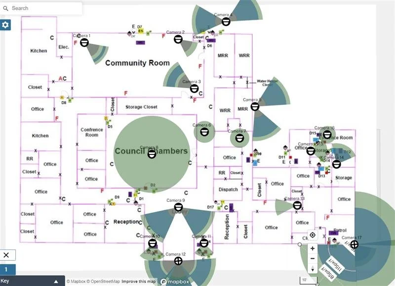 A floor plan of a community building showing rooms, offices, conference rooms, storage, kitchen, council chambers, and various camera locations for security.