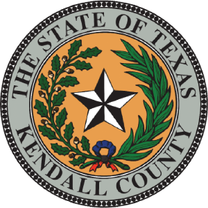 Seal of Kendall County, Texas, featuring a star, oak and laurel branches, a blue ribbon, and the text "The State of Texas Kendall County."