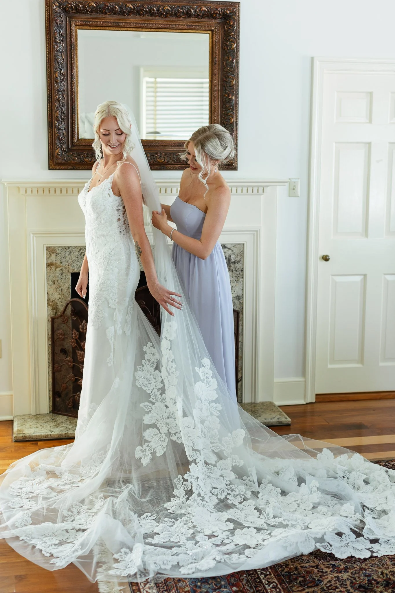 Wedding photography of a bride and her bridesmaid in front of the fireplace inside the Mansion at Drumore Estate