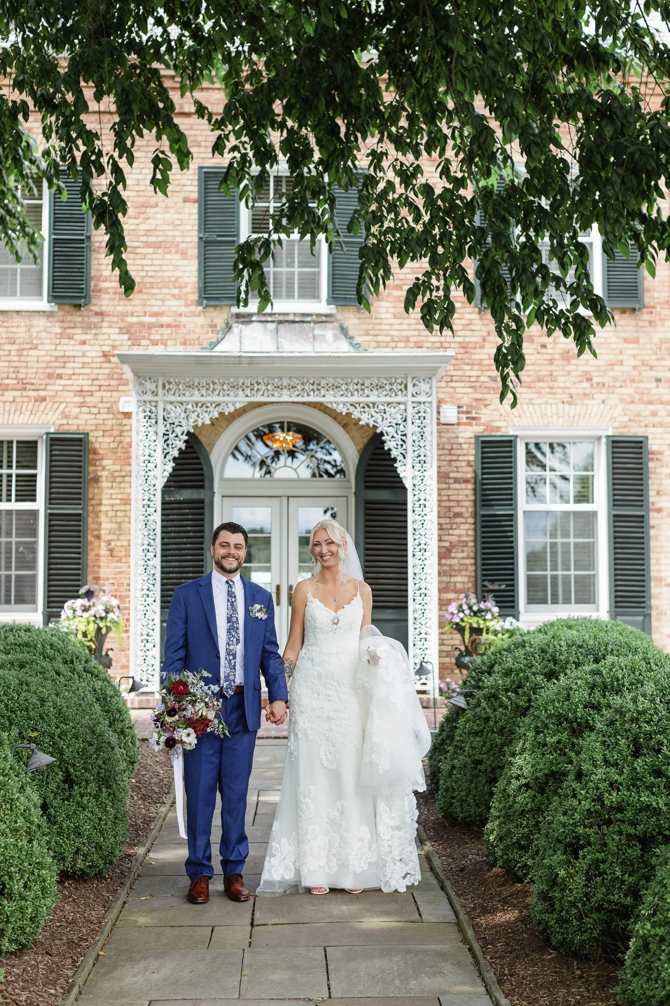 Romantic wedding photo of a couple walking in front of The Mansion in Pequea.