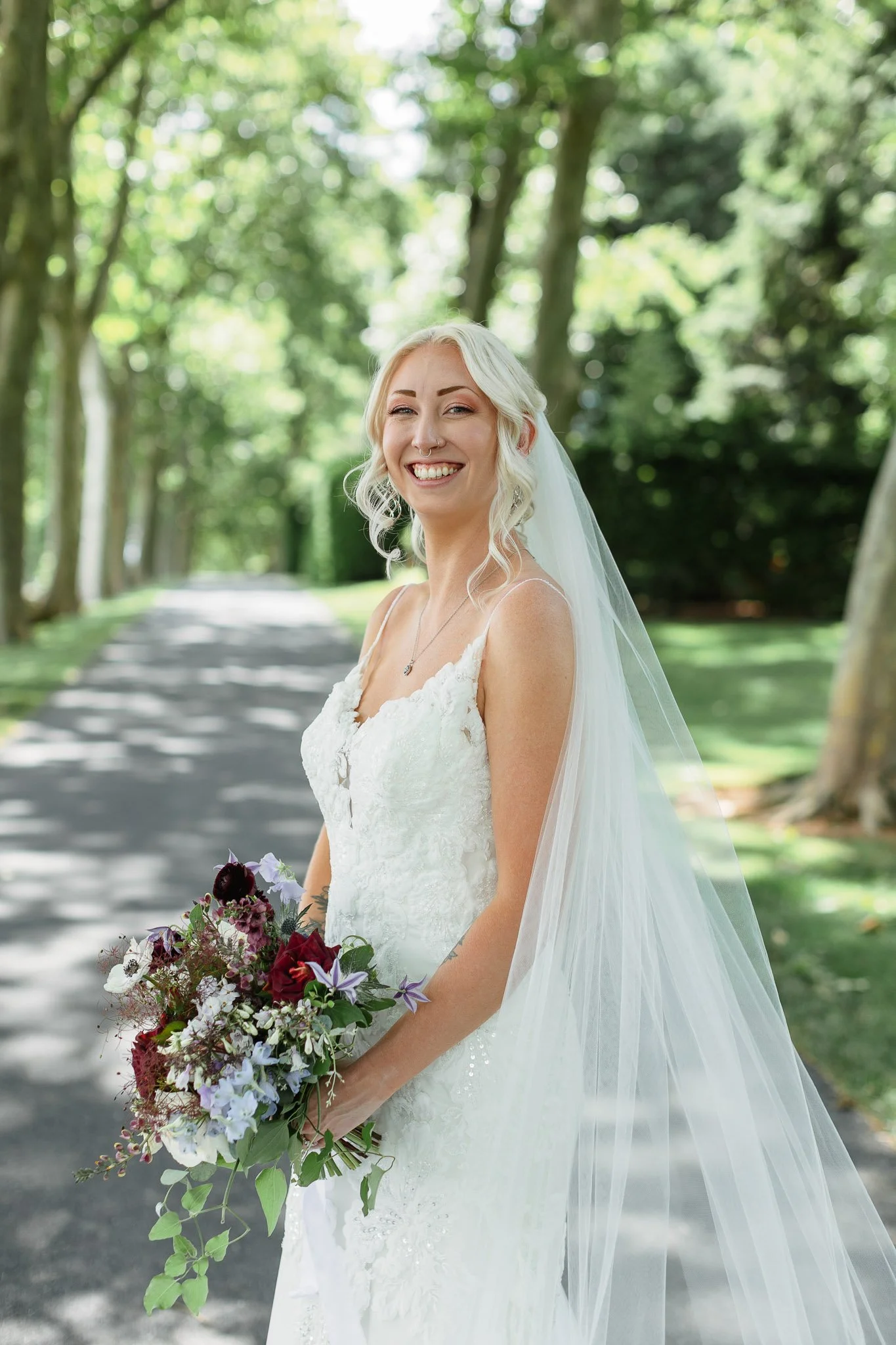A wedding photo focusing on the intricate floral patterns of the bride's lacy white wedding dress.