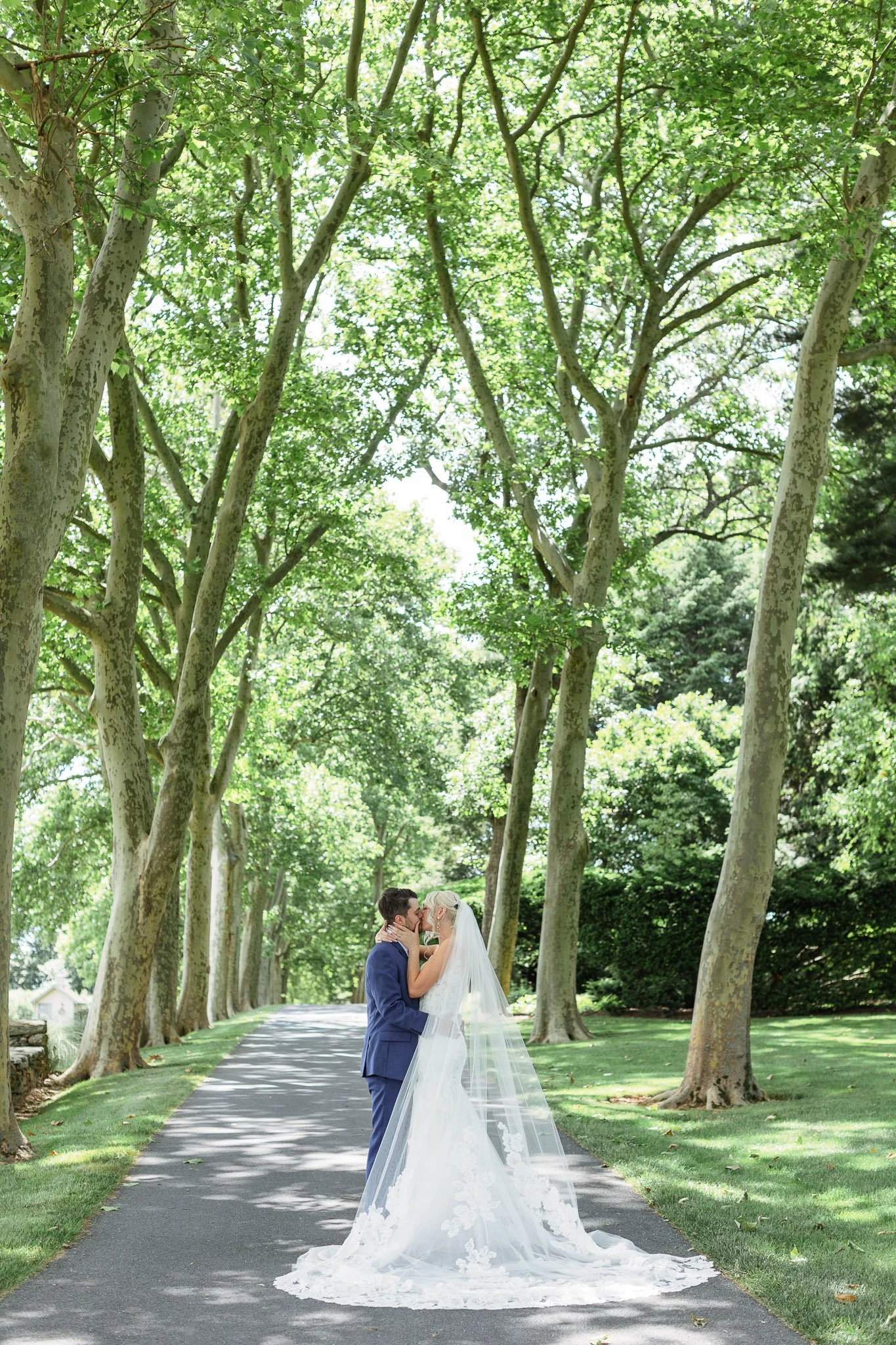 A wedding photographer captures the couple standing back-to-back amidst the lush greenery of Pequea, Pennsylvania.